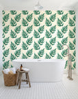 Driftwood Fern Emerald fern frond wallpaper behind a freestanding tub in a bright coastal bathroom