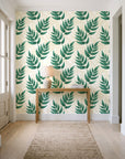 Driftwood Fern Emerald fern frond wallpaper behind a console table in a light entry hallway