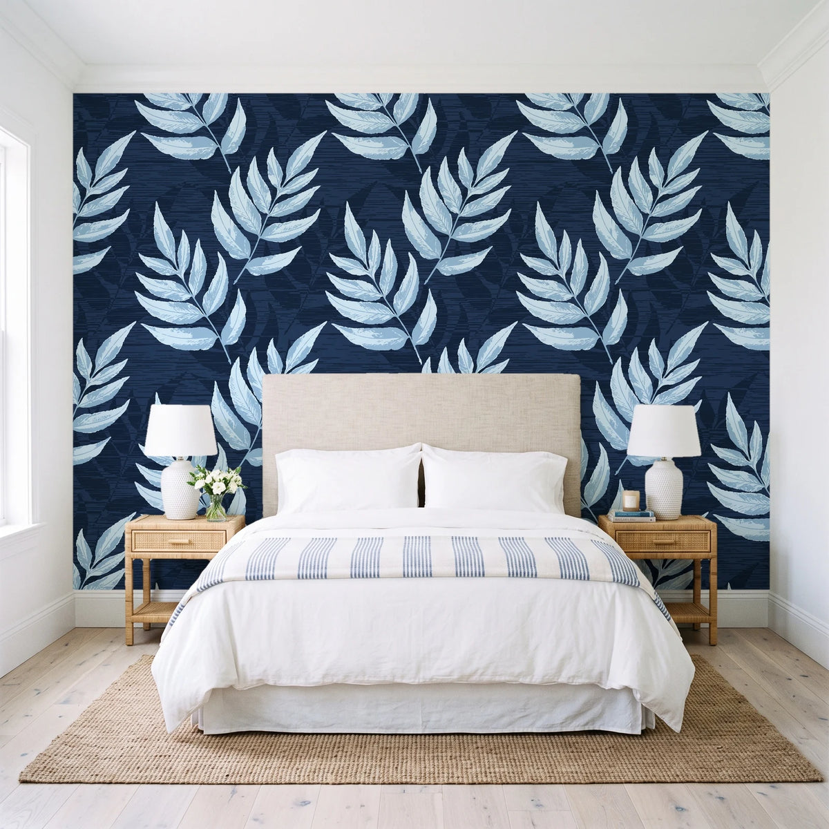 Driftwood Fern Midnight fern frond wallpaper behind a queen bed in a bright coastal bedroom