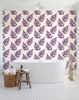 Driftwood Fern Plum fern frond wallpaper behind a freestanding tub in a bright coastal bathroom
