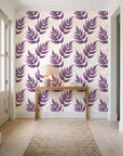 Driftwood Fern Plum fern frond wallpaper behind a console table in a light entry hallway
