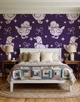 Duckling Waltz Plum ducklings wallpaper behind a white cottage bed with a patchwork quilt in a cozy cottagecore bedroom