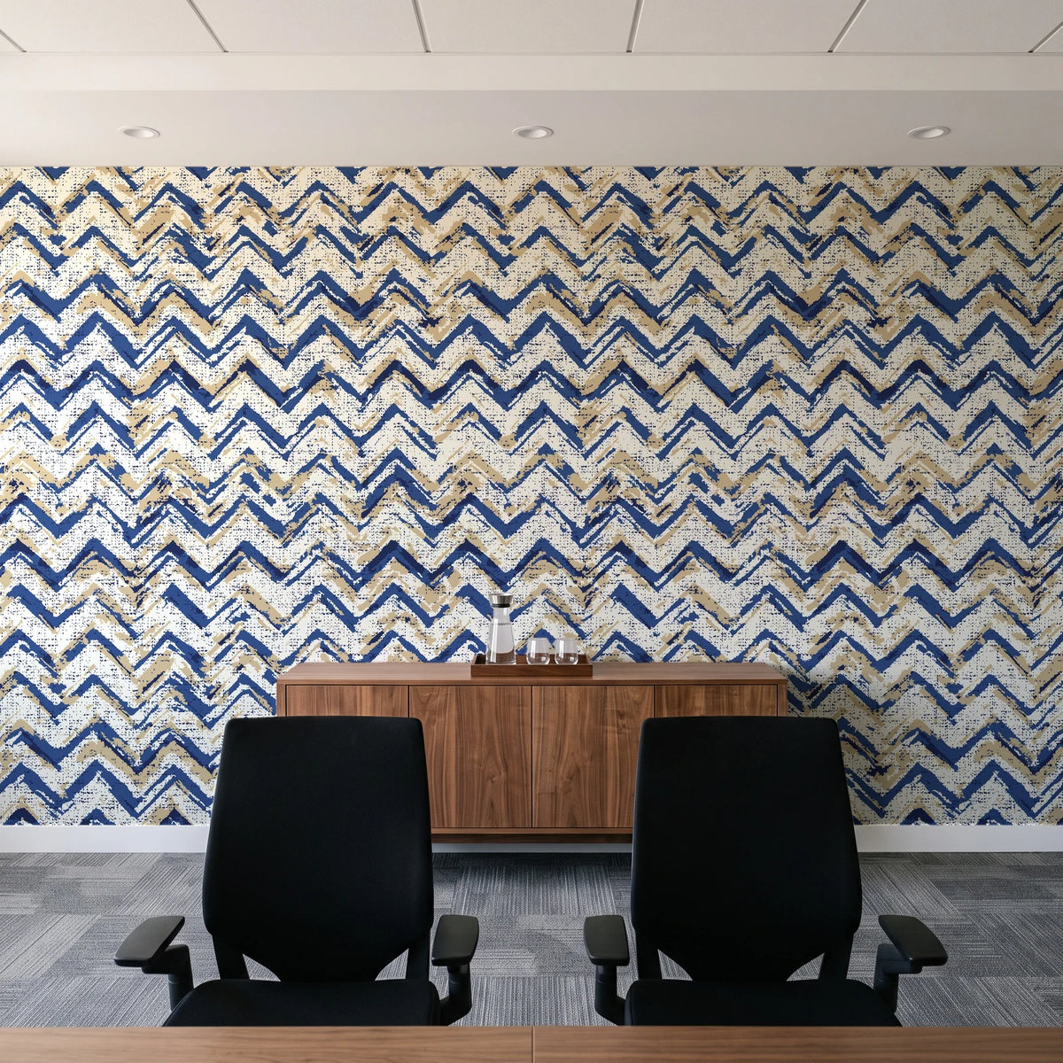 Dusk Passage Indigo chevron wallpaper above a walnut credenza in a modern conference room