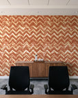 Dusk Passage Terracotta chevron wallpaper above a walnut credenza in a modern conference room
