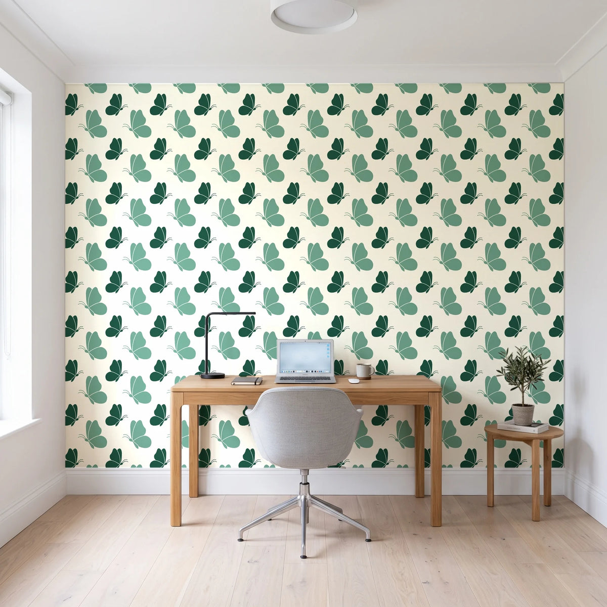 Dust & Wing Emerald butterflies wallpaper behind a modern oak desk in a bright home office
