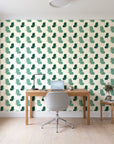 Dust & Wing Emerald butterflies wallpaper behind a modern oak desk in a bright home office