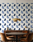 Dust & Wing Navy butterflies wallpaper behind a walnut credenza and round table in an elegant dining room