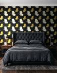 Dust & Wing Onyx butterflies wallpaper behind a tufted headboard in a dark, moody bedroom