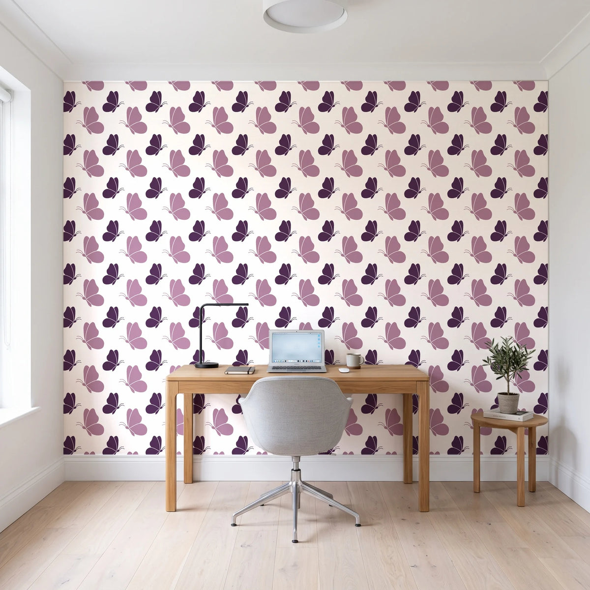Dust & Wing Plum butterflies wallpaper behind a modern oak desk in a bright home office
