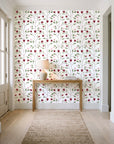 Ember & Leaf Garnet botanical floral wallpaper behind a console table in a light entry hallway