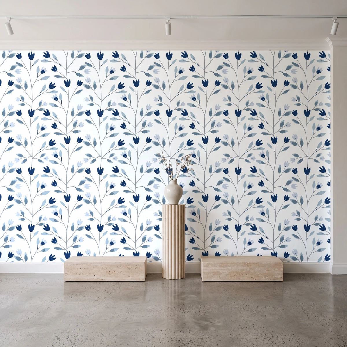 Ember & Leaf Midnight botanical floral wallpaper behind a travertine pedestal and vase in a minimal boutique