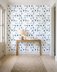 Ember & Leaf Midnight botanical floral wallpaper behind a console table in a light entry hallway