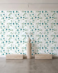 Ember & Leaf Peacock botanical floral wallpaper behind a travertine pedestal and vase in a minimal boutique