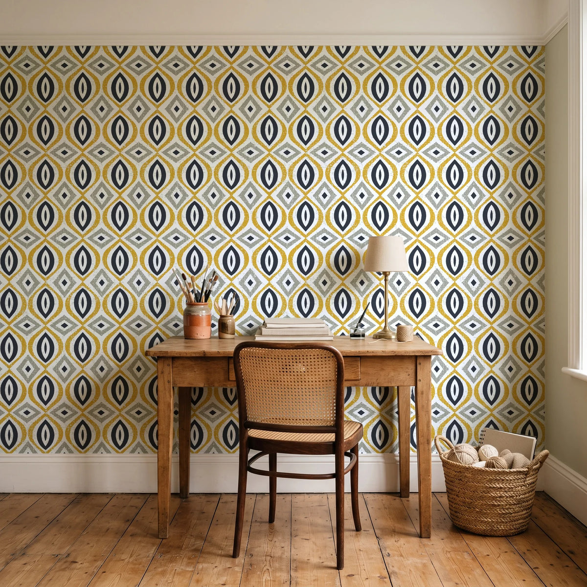 Ember & Iron Mustard retro ogee wallpaper behind a vintage writing desk in a cozy craft-room home office