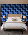 Ember Mosaic Midnight retro geometric wallpaper behind the headboard of a king bed in a contemporary hotel guest room