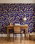 Evening Garden Plum botanical floral wallpaper behind a vintage writing desk in a cozy craft-room home office