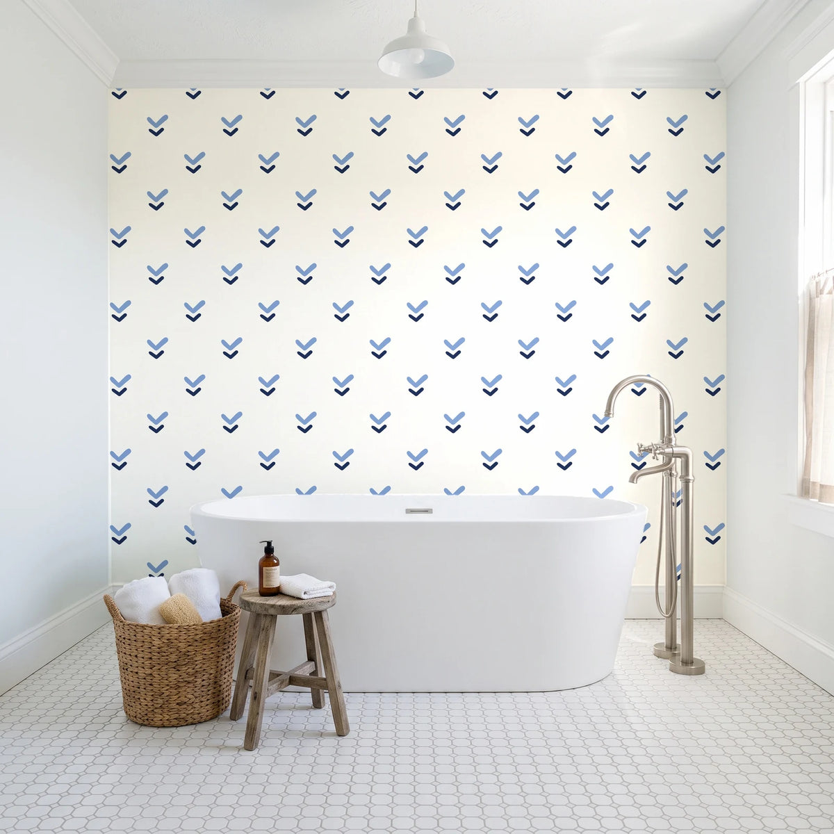 Falling Grace Navy chevron wallpaper behind a freestanding tub in a bright coastal bathroom