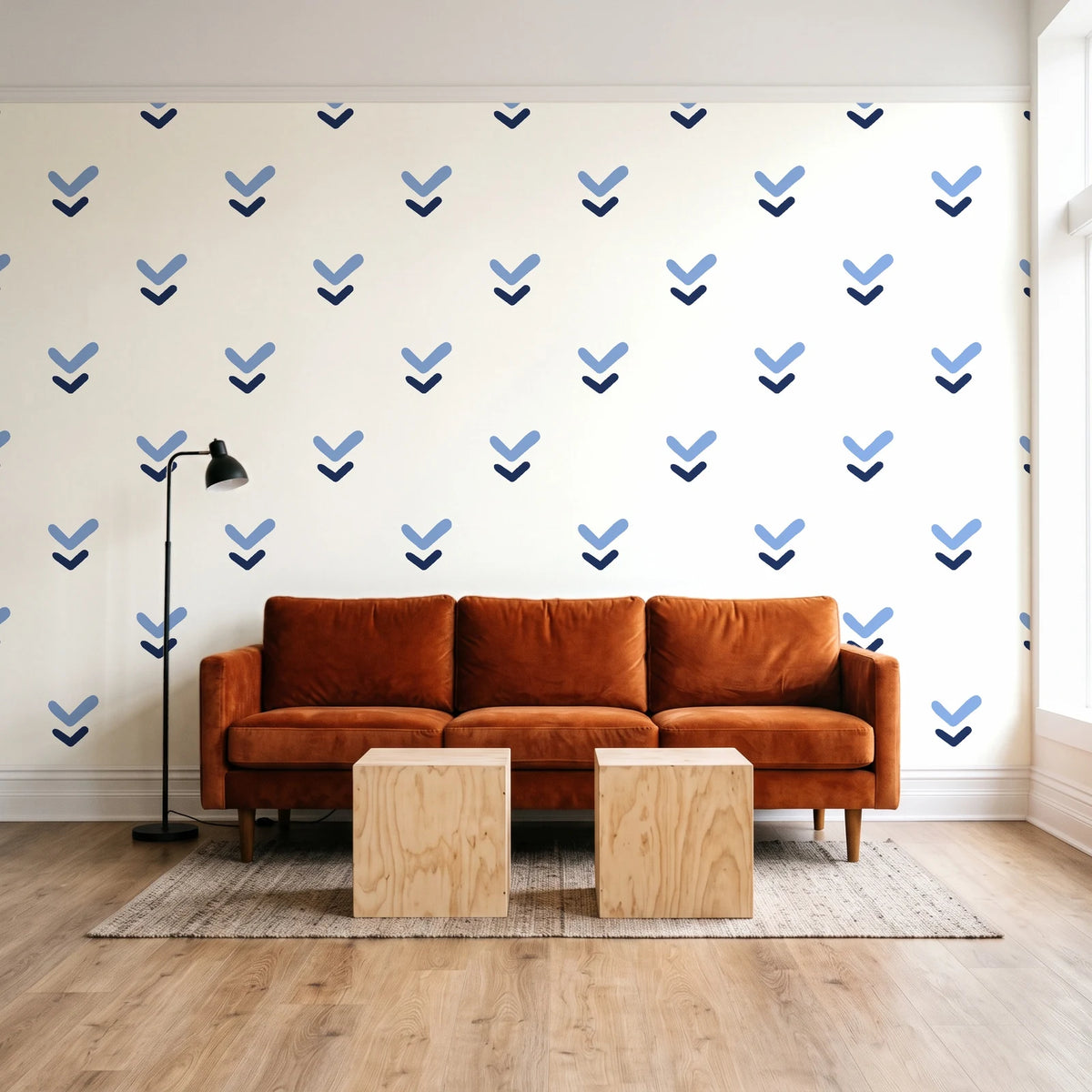 Falling Grace Navy chevron wallpaper behind a rust velvet sofa in a bright coworking lounge