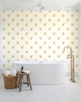 Falling Grace Ochre chevron wallpaper behind a freestanding tub in a bright coastal bathroom