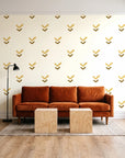 Falling Grace Ochre chevron wallpaper behind a rust velvet sofa in a bright coworking lounge