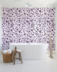 First Bloom Plum ditsy floral wallpaper behind a freestanding tub in a bright coastal bathroom