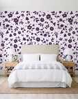 First Bloom Plum ditsy floral wallpaper behind a queen bed in a bright coastal bedroom