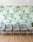 Frost Garden Veil Sage floral wallpaper behind a row of upholstered chairs in a bright clinic waiting room