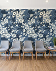 Frost Garden Veil Slate floral wallpaper behind a row of upholstered chairs in a bright clinic waiting room