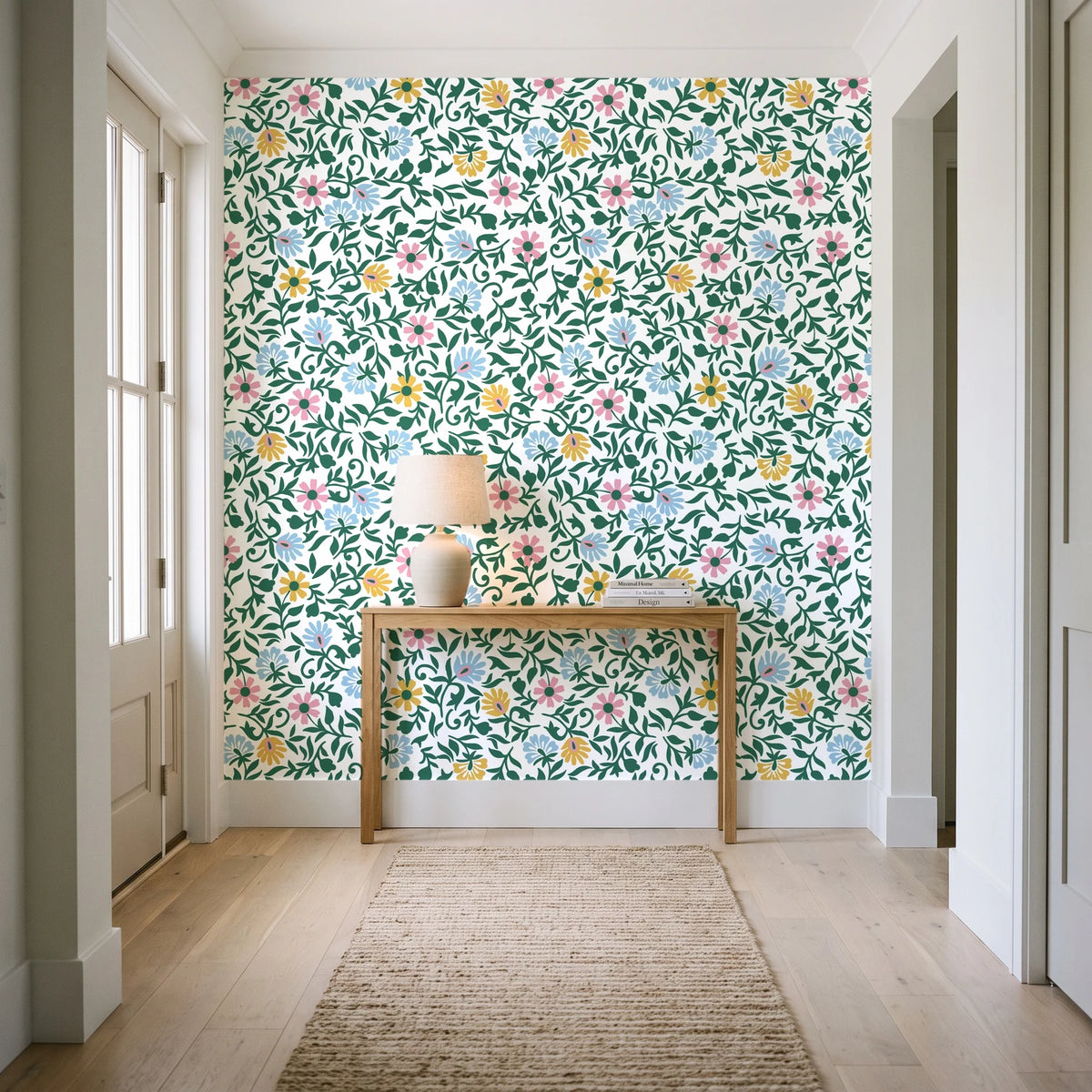 Garden Reverie Emerald floral wallpaper behind a console table in a light entry hallway