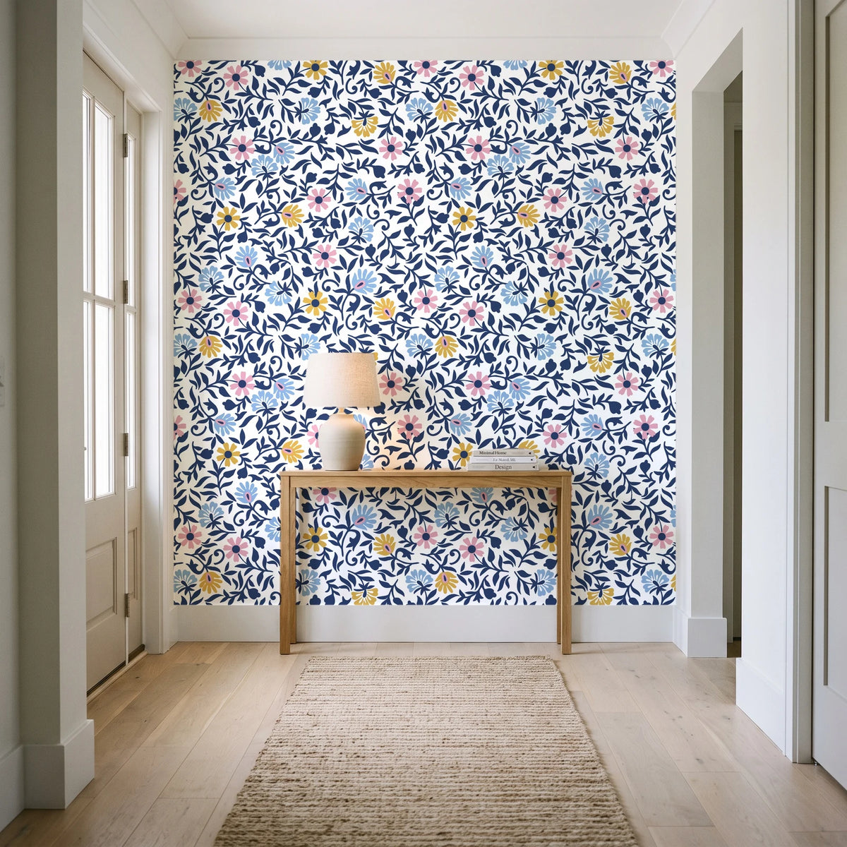 Garden Reverie Midnight floral wallpaper behind a console table in a light entry hallway