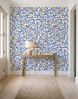 Garden Reverie Midnight floral wallpaper behind a console table in a light entry hallway