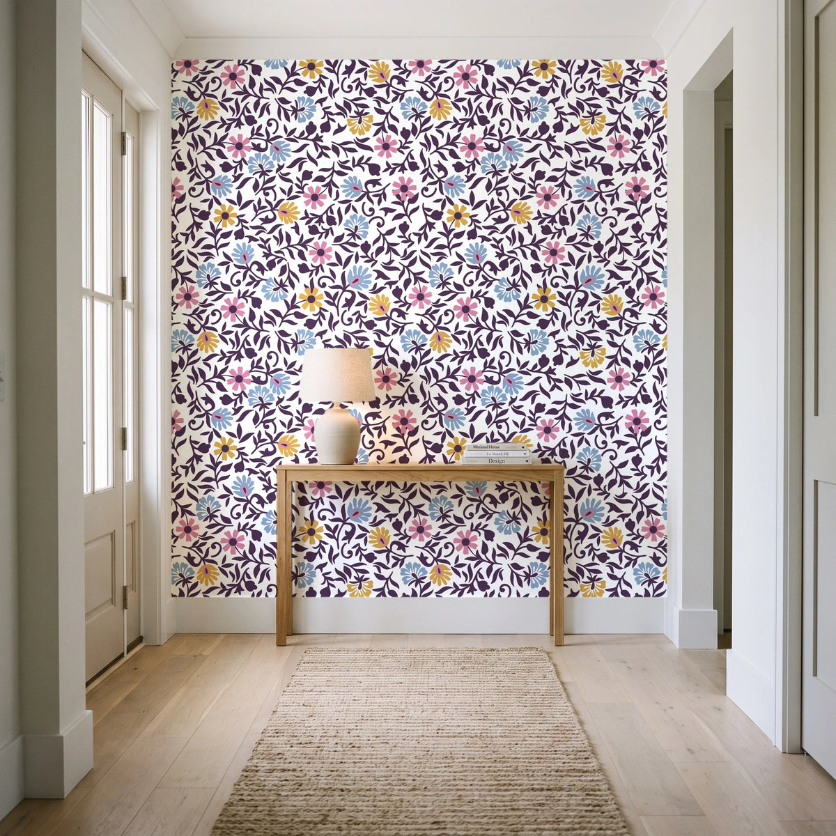 Garden Reverie Plum floral wallpaper behind a console table in a light entry hallway