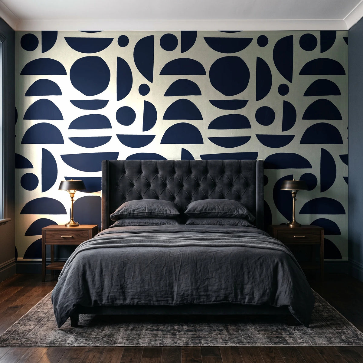 Geo Eclipse Midnight organic shapes wallpaper behind a tufted headboard in a dark, moody bedroom