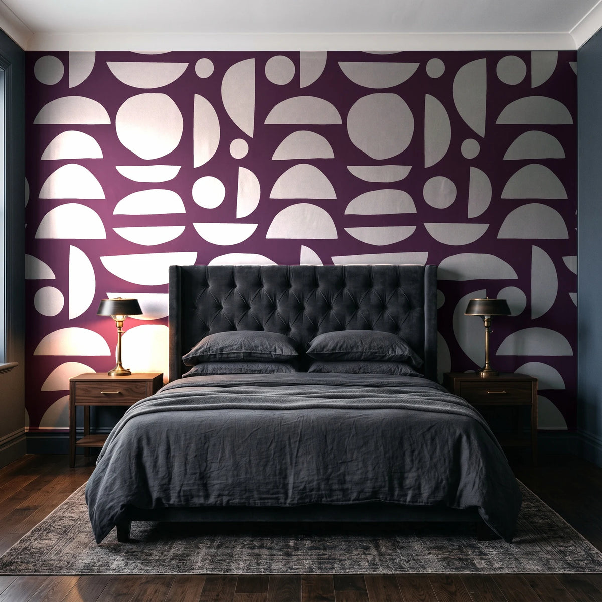 Geo Eclipse Plum organic shapes wallpaper behind a tufted headboard in a dark, moody bedroom