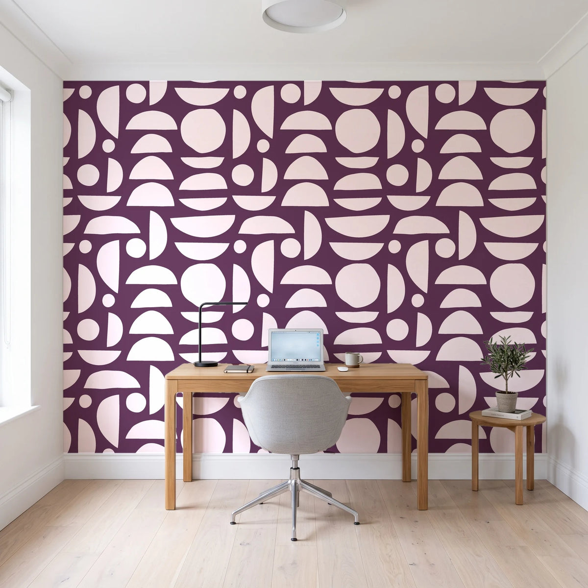 Geo Eclipse Plum organic shapes wallpaper behind a modern oak desk in a bright home office