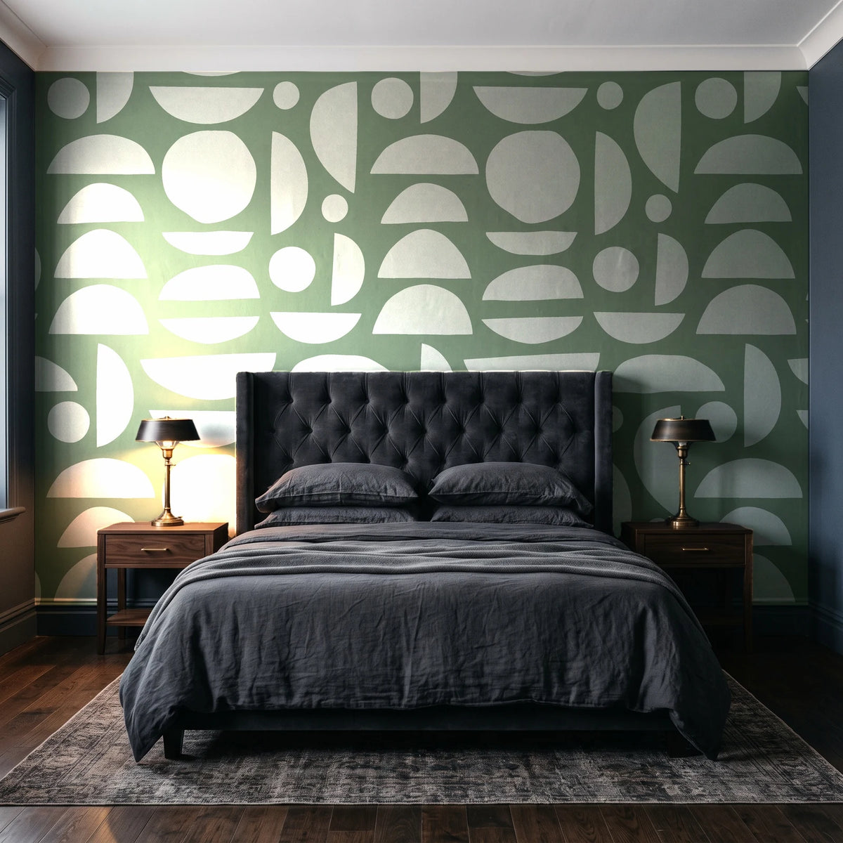 Geo Eclipse Sage organic shapes wallpaper behind a tufted headboard in a dark, moody bedroom