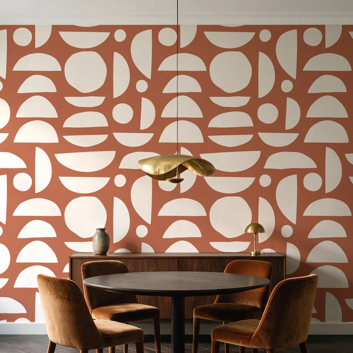 Geo Eclipse Terracotta organic shapes wallpaper behind a walnut credenza and round table in an elegant dining room