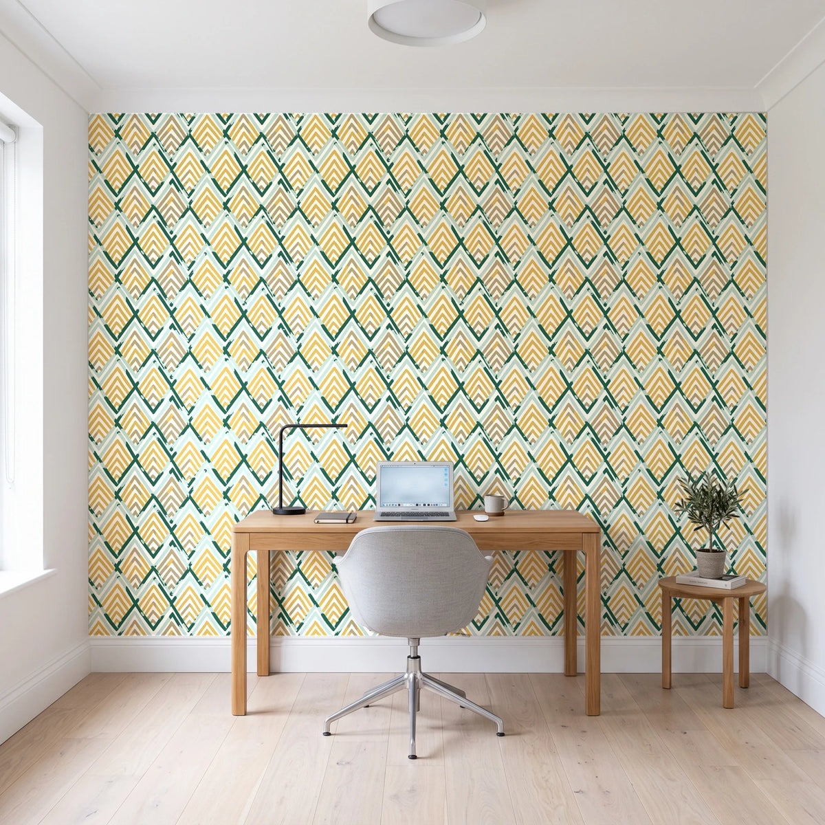Gilded Crossing Emerald chevron geometric wallpaper behind a modern oak desk in a bright home office