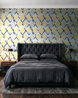 Gilded Crossing Navy chevron geometric wallpaper behind a tufted headboard in a dark, moody bedroom
