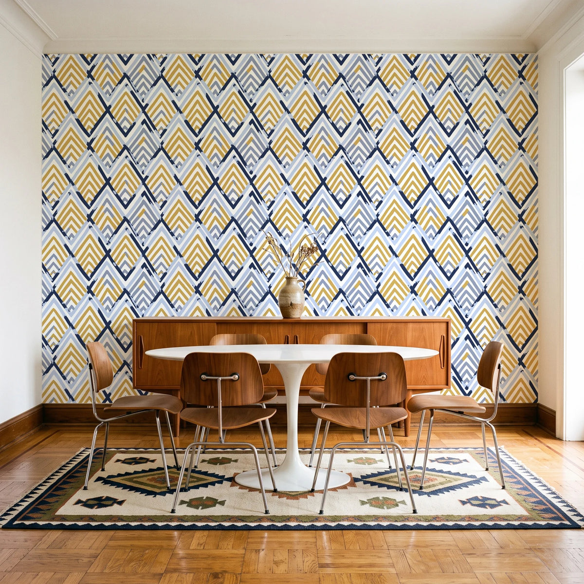 Gilded Crossing Navy chevron geometric wallpaper in a mid-century dining room with a teak sideboard and tulip table