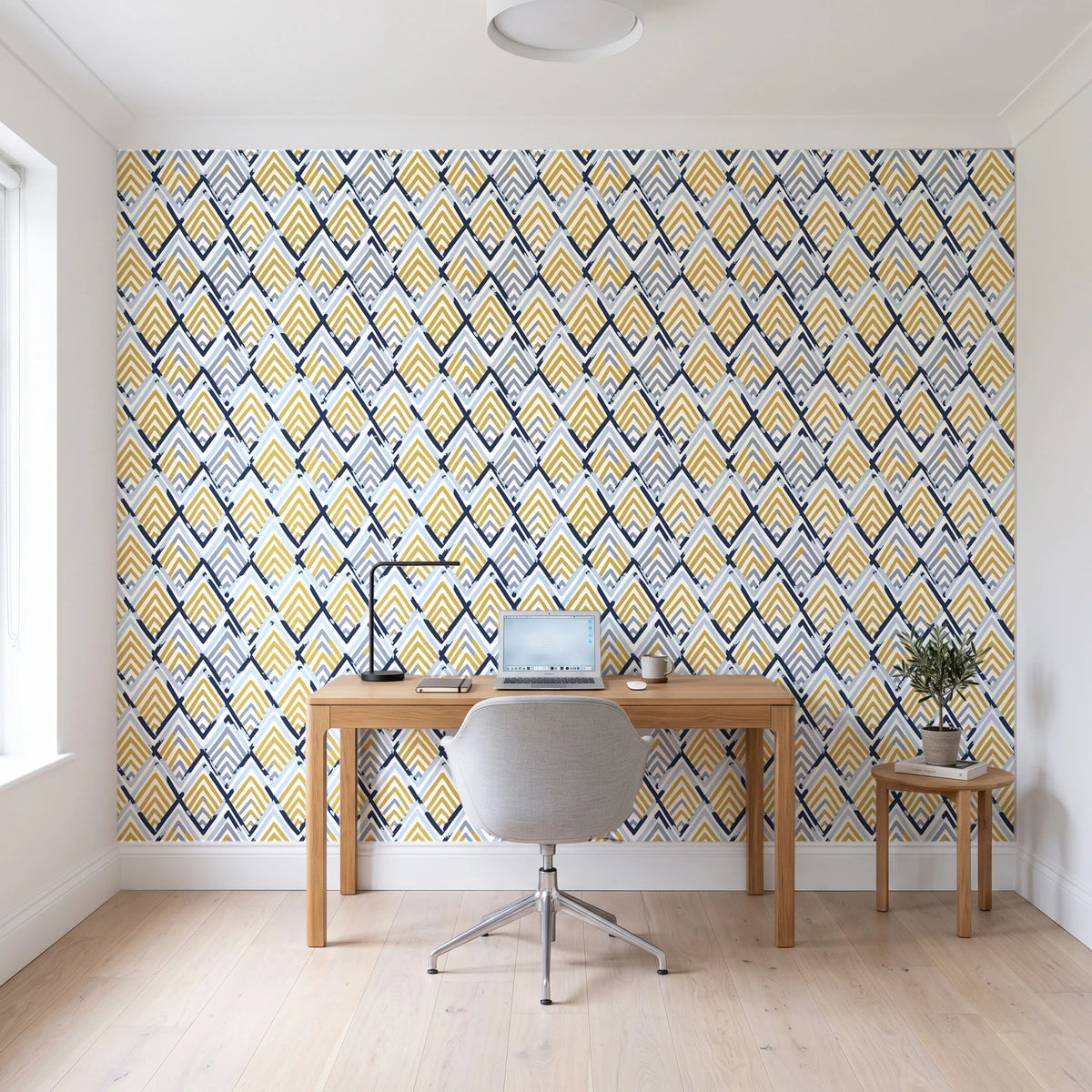 Gilded Crossing Navy chevron geometric wallpaper behind a modern oak desk in a bright home office