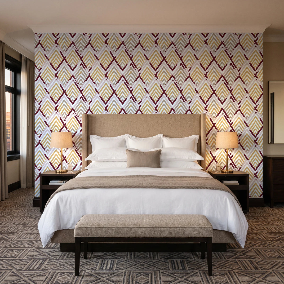Gilded Crossing Oxblood chevron geometric wallpaper behind the headboard of a king bed in a contemporary hotel guest room