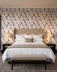 Gilded Crossing Oxblood chevron geometric wallpaper behind the headboard of a king bed in a contemporary hotel guest room