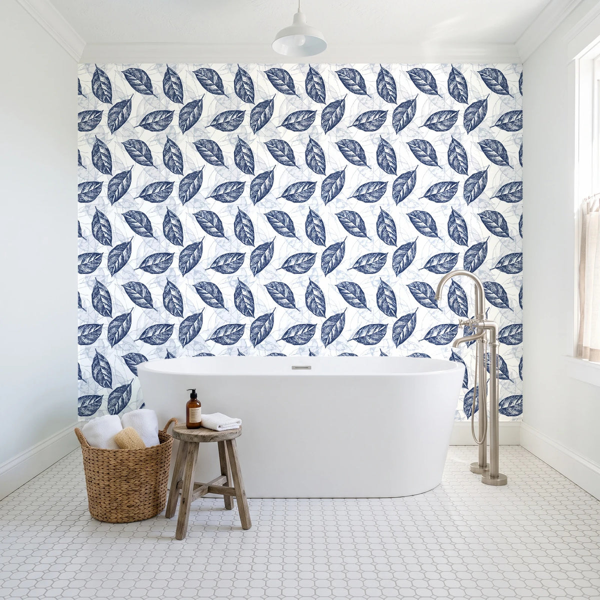 Gilded Frond Navy leaf wallpaper behind a freestanding tub in a bright coastal bathroom