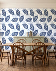 Gilded Frond Navy leaf wallpaper in a farmhouse dining room with a sage sideboard and rustic trestle table