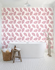 Gilded Frond Rose leaf wallpaper behind a freestanding tub in a bright coastal bathroom