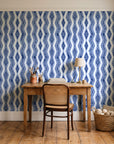 Gilded Rain Indigo geometric wallpaper behind a vintage writing desk in a cozy craft-room home office