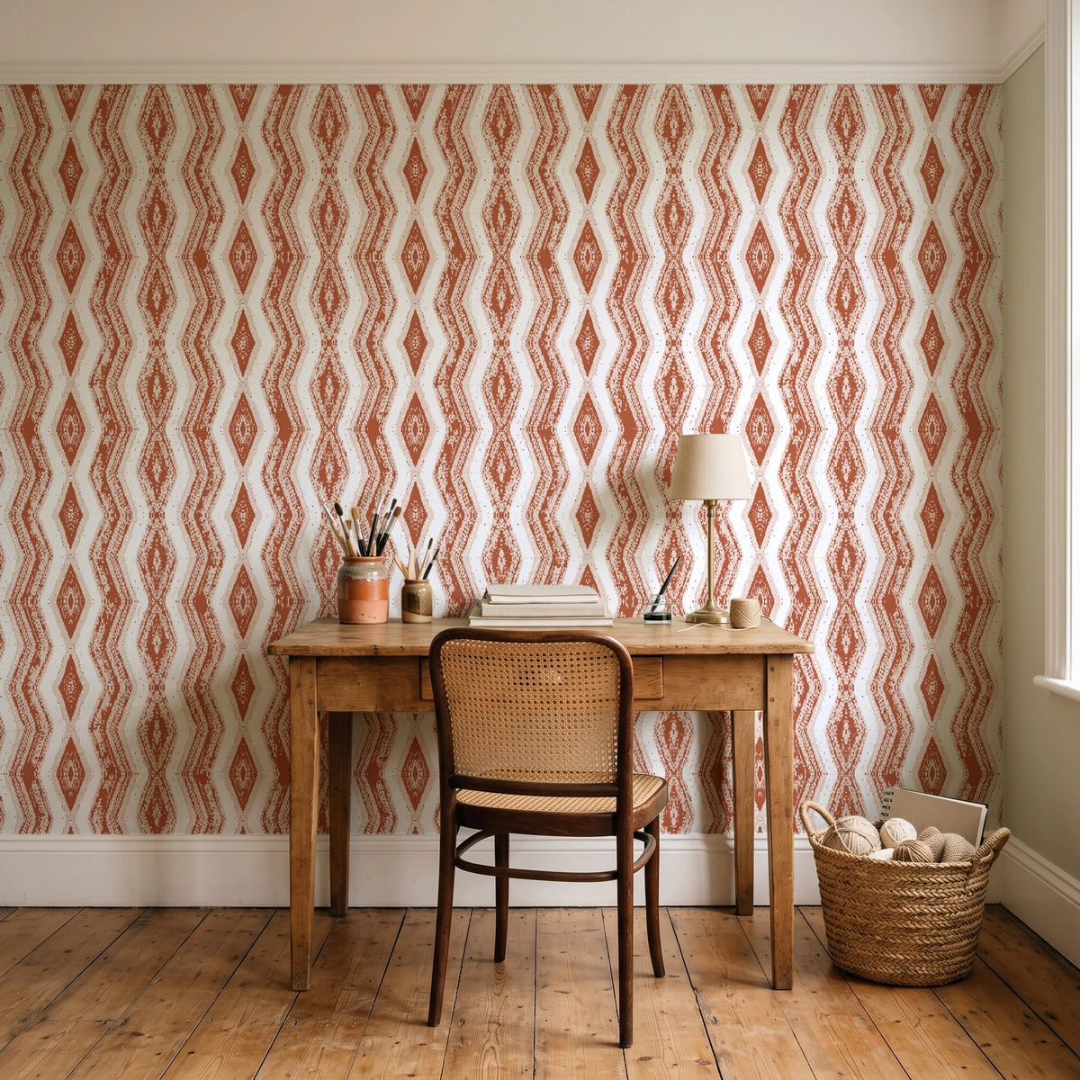 Gilded Rain Terracotta geometric wallpaper behind a vintage writing desk in a cozy craft-room home office