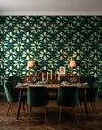 Gilt Scatter Emerald floral scatter wallpaper in a dark moody dining room with a candlelit table