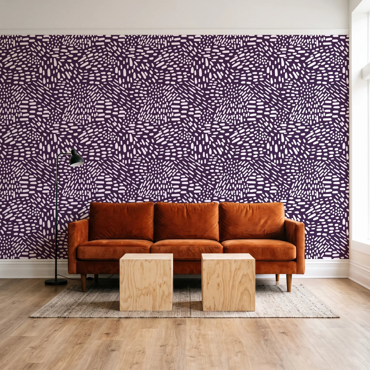 Grain Shift Aubergine minimalist dash wallpaper behind a rust velvet sofa in a bright coworking lounge